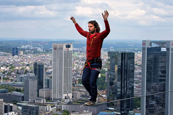 Ein Slackliner vor der Skyline von Frankfurt am Main.  