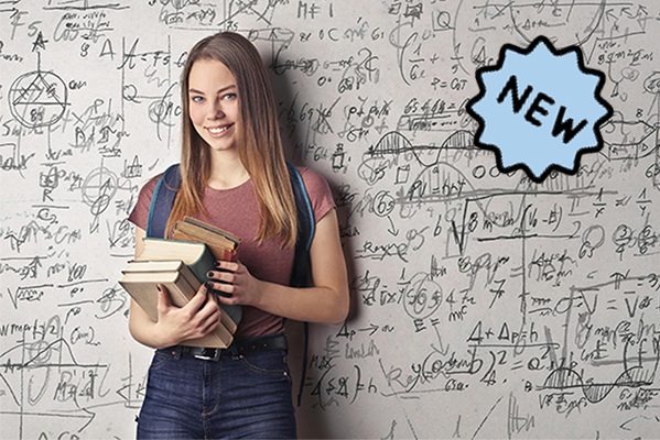 Eine junge Frau steht vor einer Wand mit Formeln und Grafiken. Sie hält Bücher in der rechten Hand und lächelt in die Kamera.