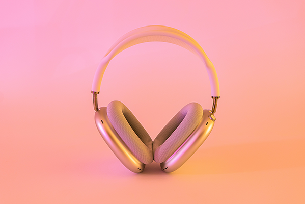 Ein glänzender On-Ear-Kopfhörer vor einem pinkfarbenen Hintergrund.